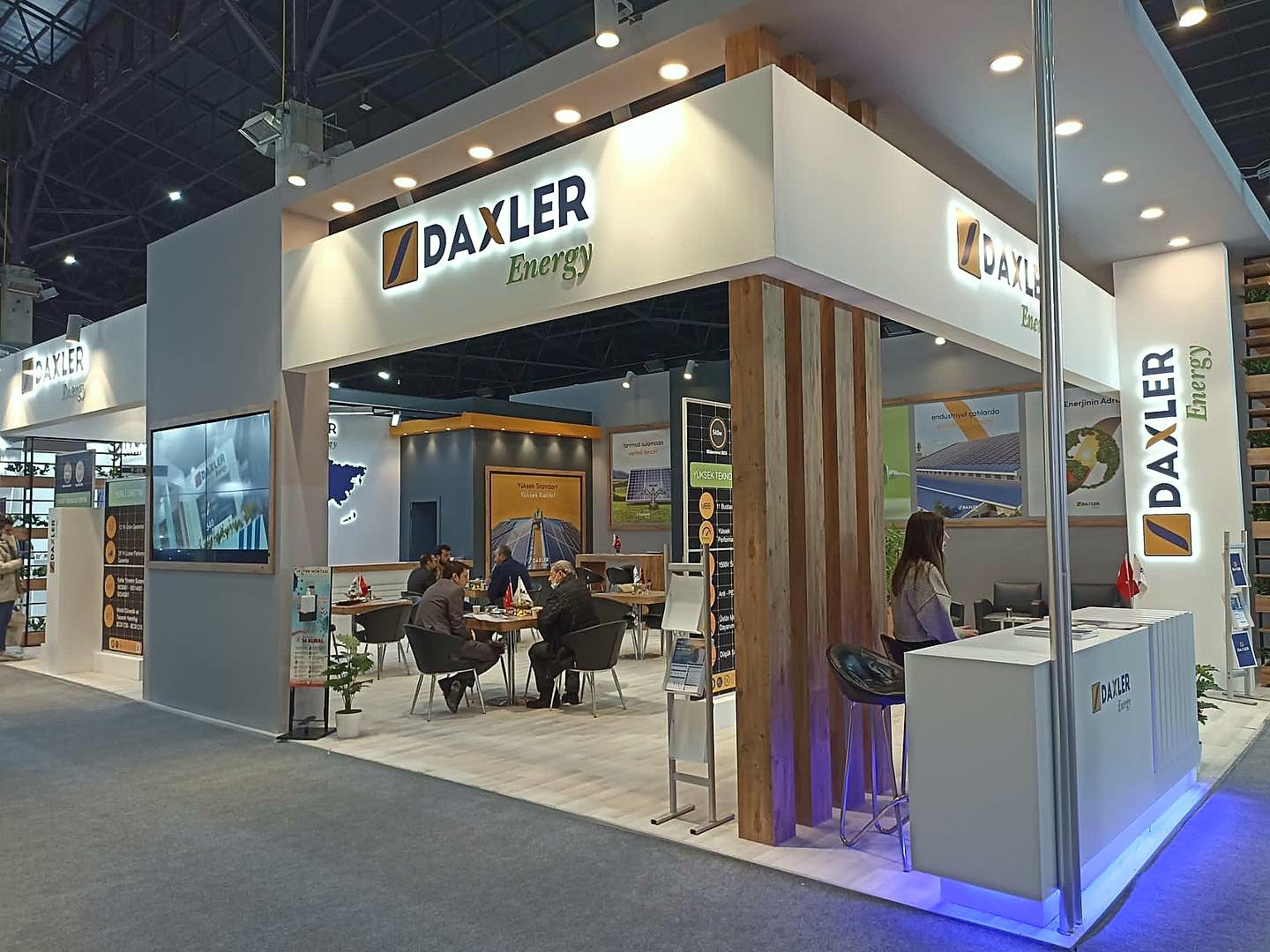 Stand d’exposition Daxler Energy au salon Solar İstanbul 2022 : Des montants en bois, un angle ouvert et des écrans intégrés présentent l’offre énergétique dans un environnement chaleureux et accessible