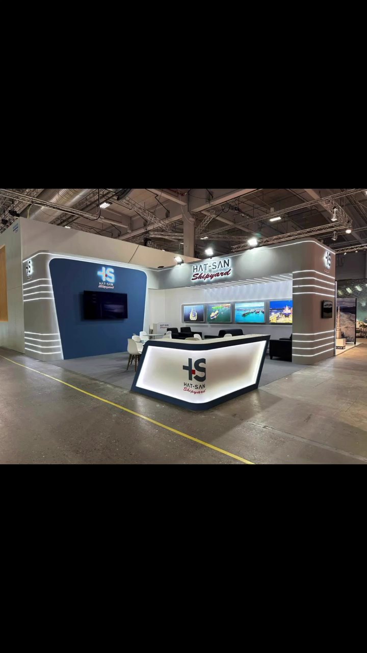 Stand d’exposition Hatsan Shipyard au salon Nor-Shipping 2023 : Des bandes métalliques horizontales, des contenus numériques intégrés et des espaces de réunion maîtrisés composent une façade forte et sobre