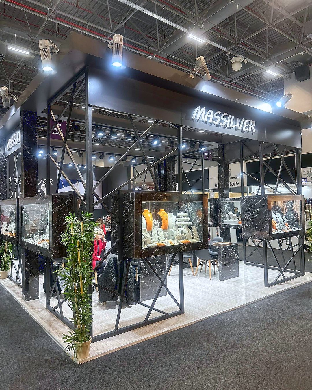 Stand d’exposition Massilver au salon Istanbul Jewelry Show 2023 : Une trame métallique sombre, des vitrines éclairées et une circulation continue mettent les pièces en valeur comme dans une galerie