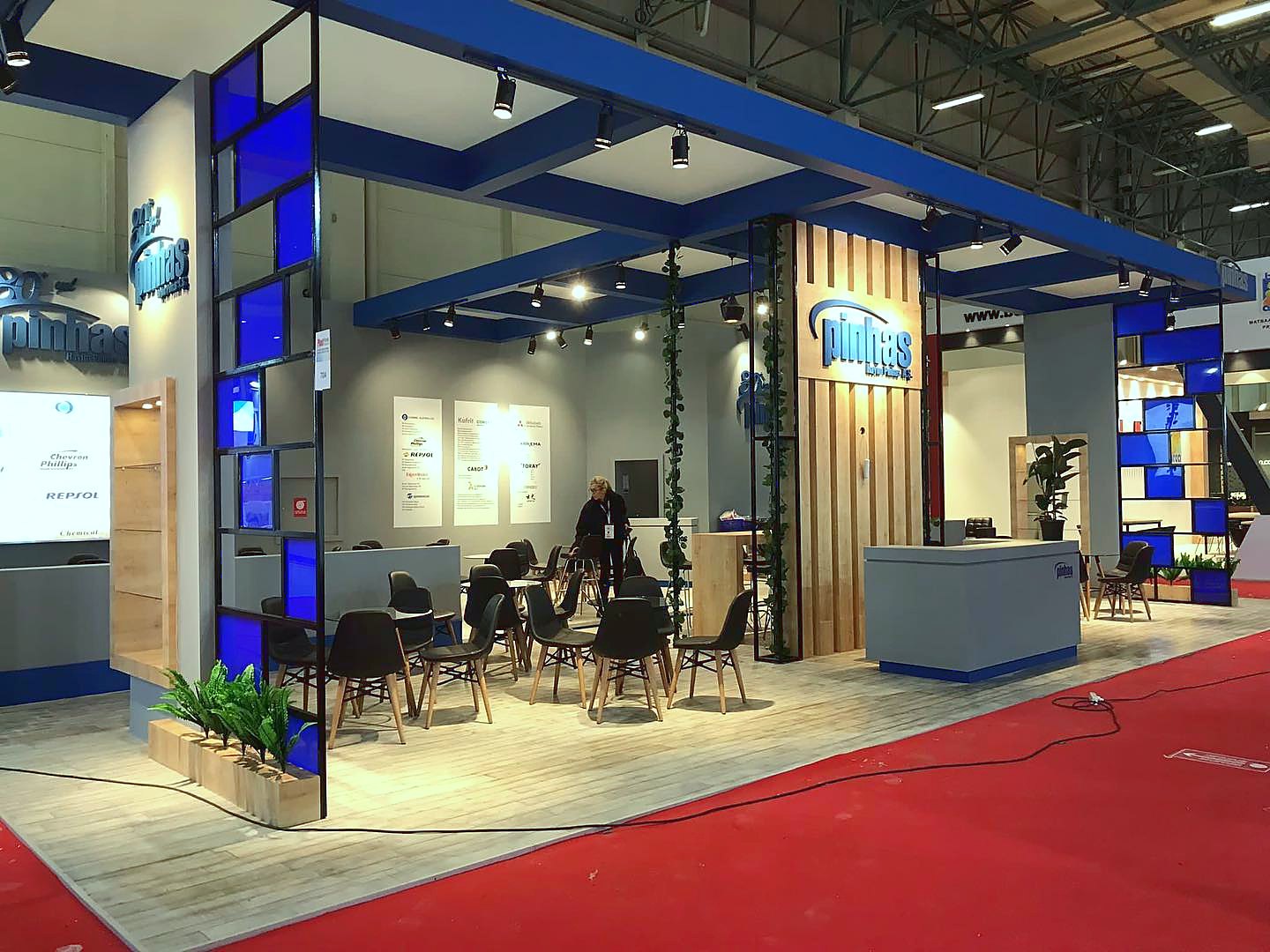 Stand d’exposition Pinhas au salon Plast Eurasia 2021 : Des surfaces bleues, des cadres en bois et des tables ouvertes donnent à la présentation technique une forte visibilité depuis les allées