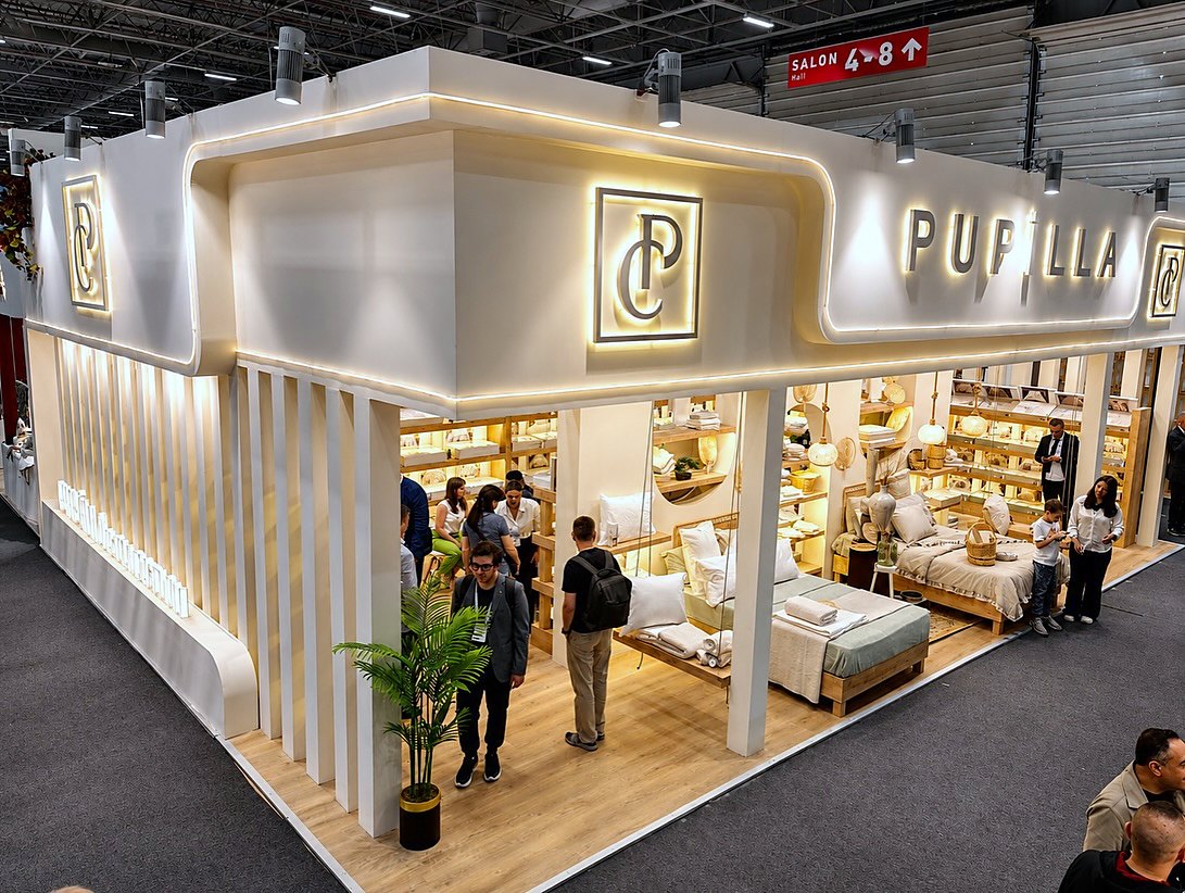Stand d’exposition Pupilla au salon HOMETEX 2026 : Un pourtour lumineux, des angles ouverts et une présentation en strates réunissent la collection textile dans un espace chaleureux et accessible